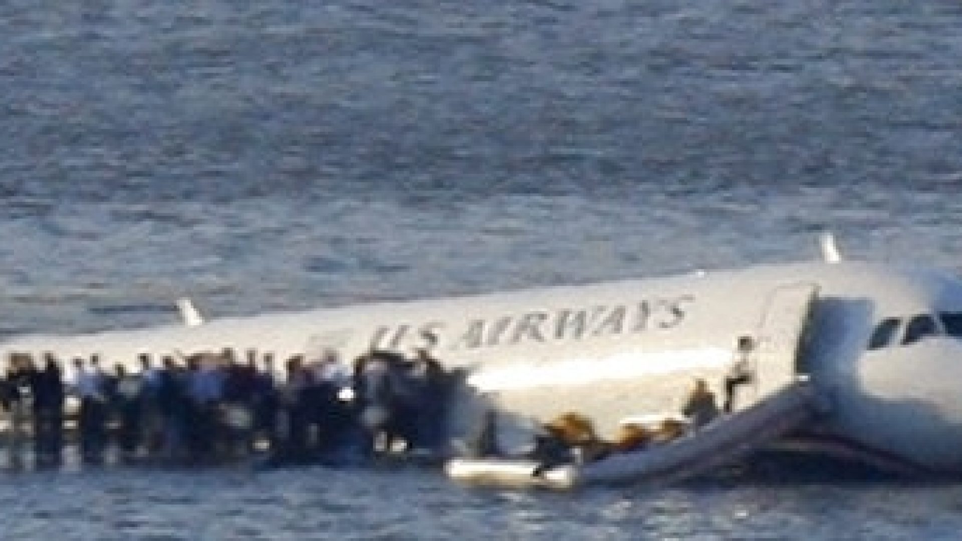 Passengers stand on the wings of a U.S. Airways plane as a ferry pulls up to it after it landed in the Hudson River in New York
